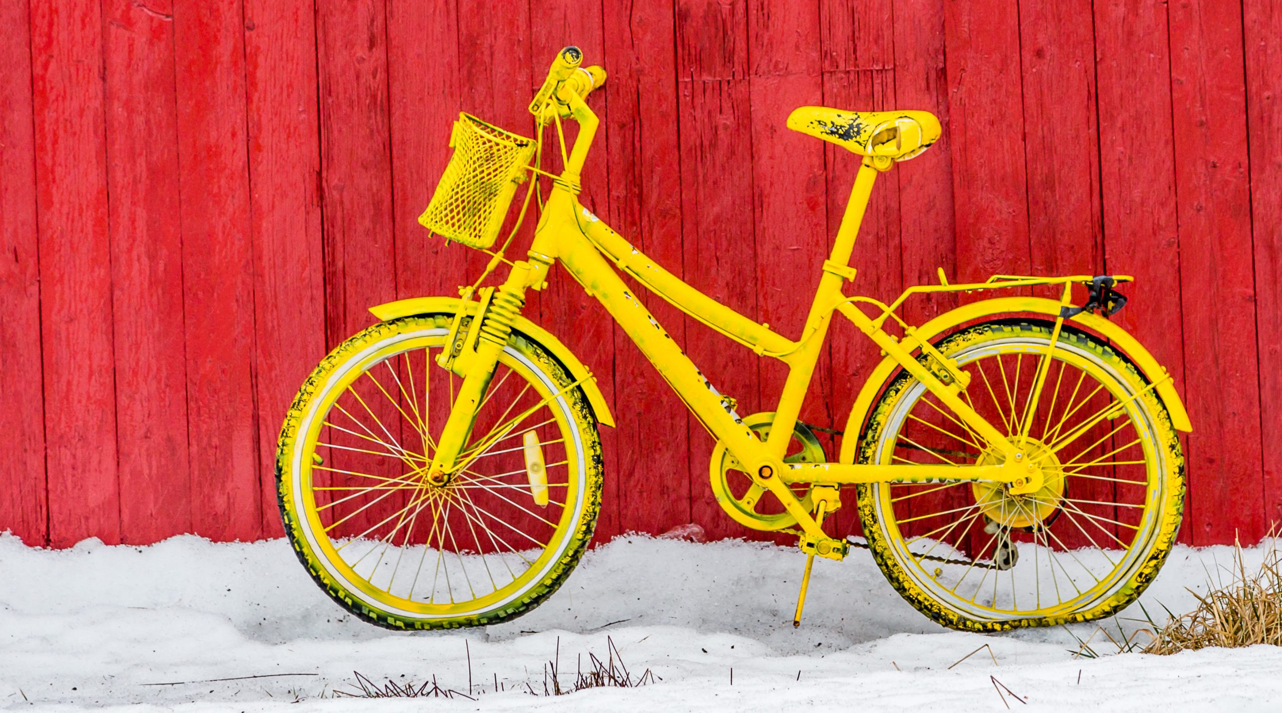 Gelbes Fahrrad an roter Wand